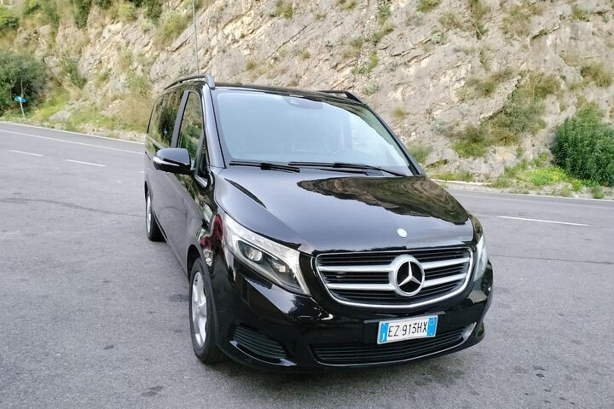 un'auto nera parcheggiata sul ciglio di una strada