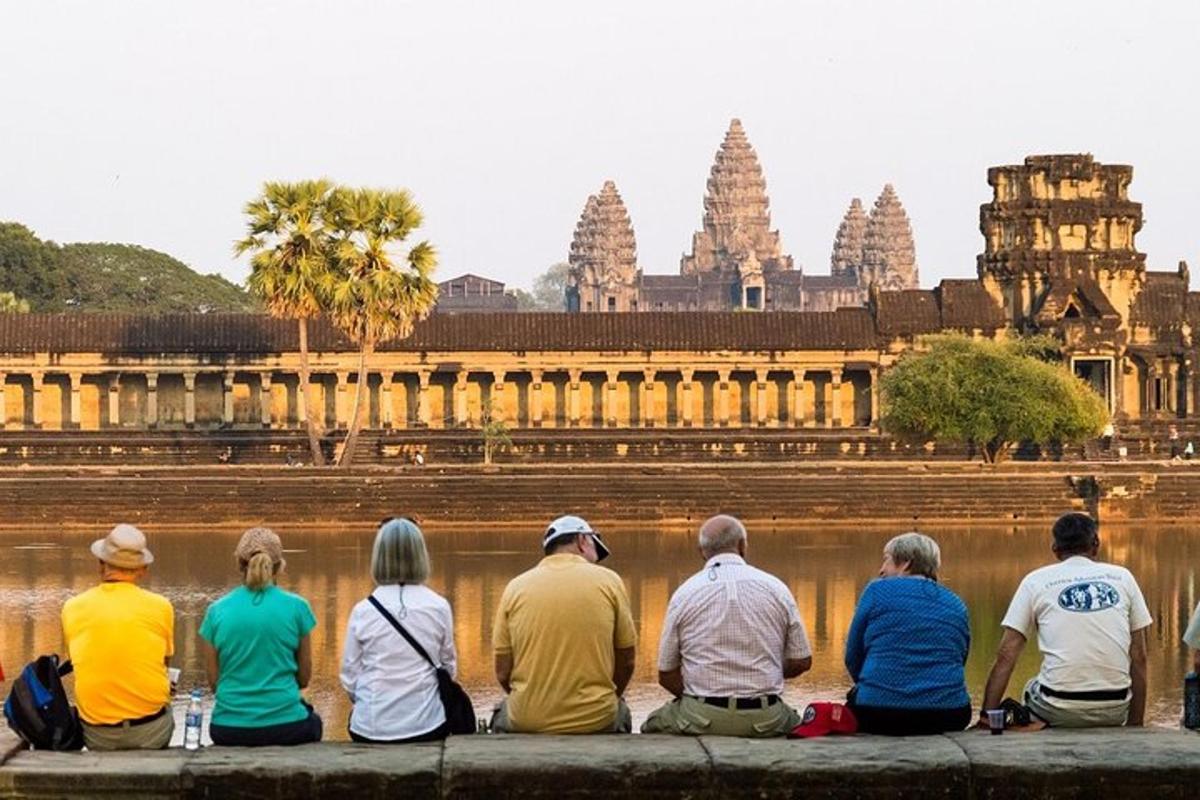 a group of people sitting on a ledge looking at a temple