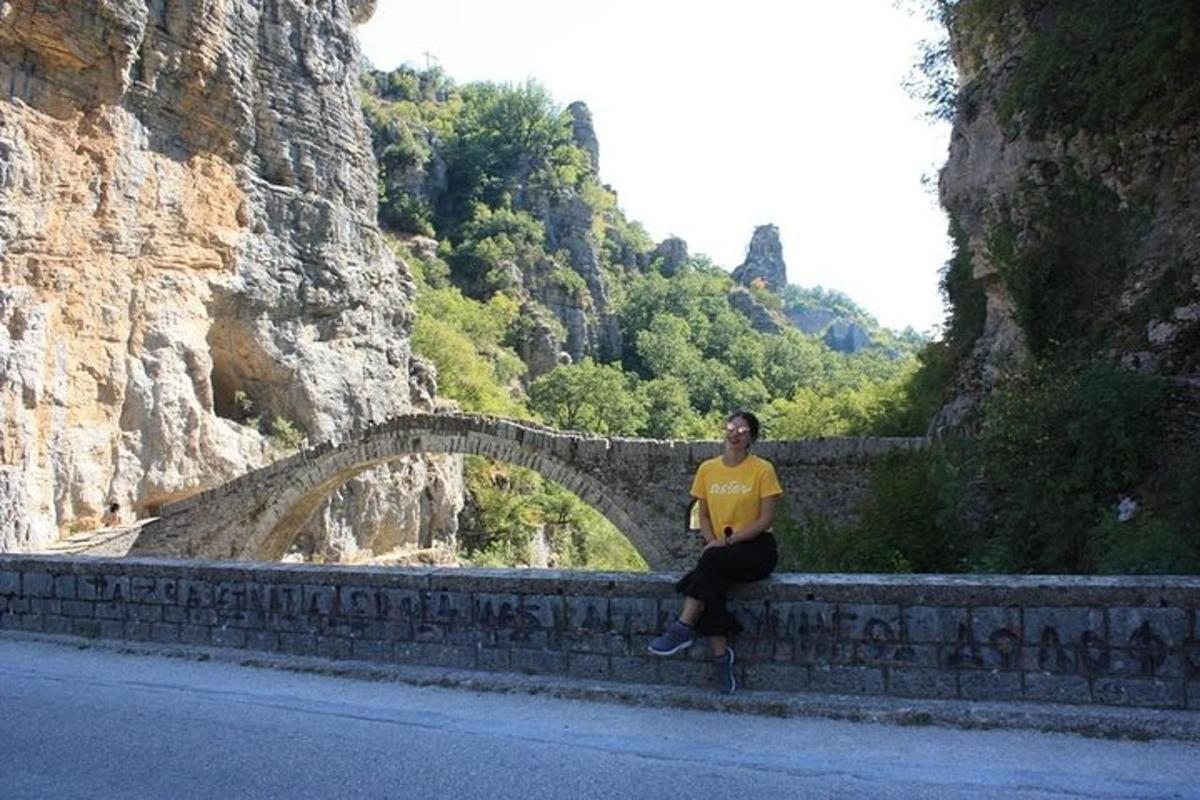 a man sitting on a wall next to a bridge