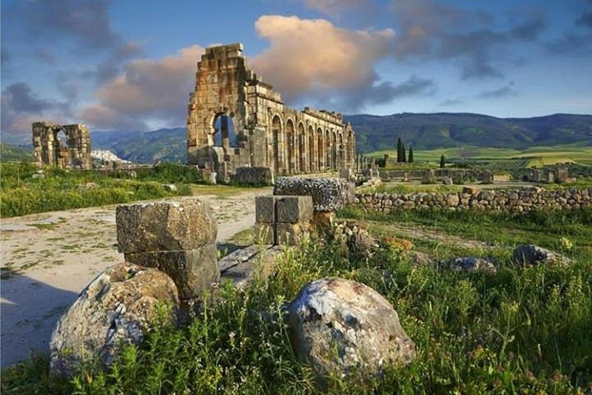 um antigo edifício de pedra em um campo com pedras