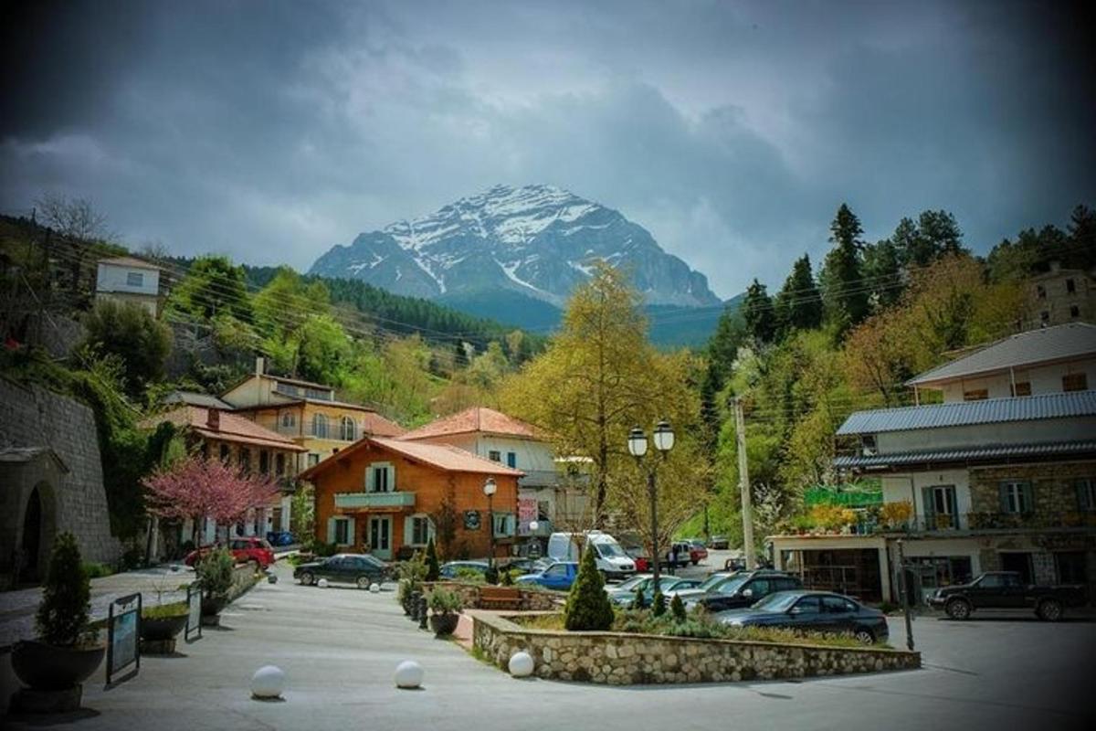 a town with a mountain in the background with cars parked