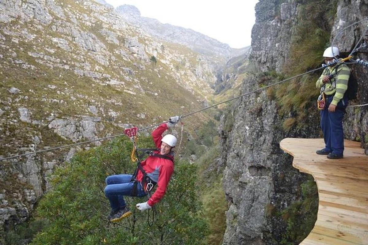 a group of people on a zip line on a mountain
