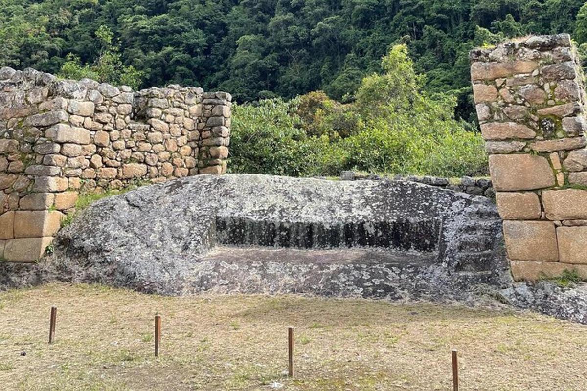 Un muro de piedra con una fuente de agua en un campo