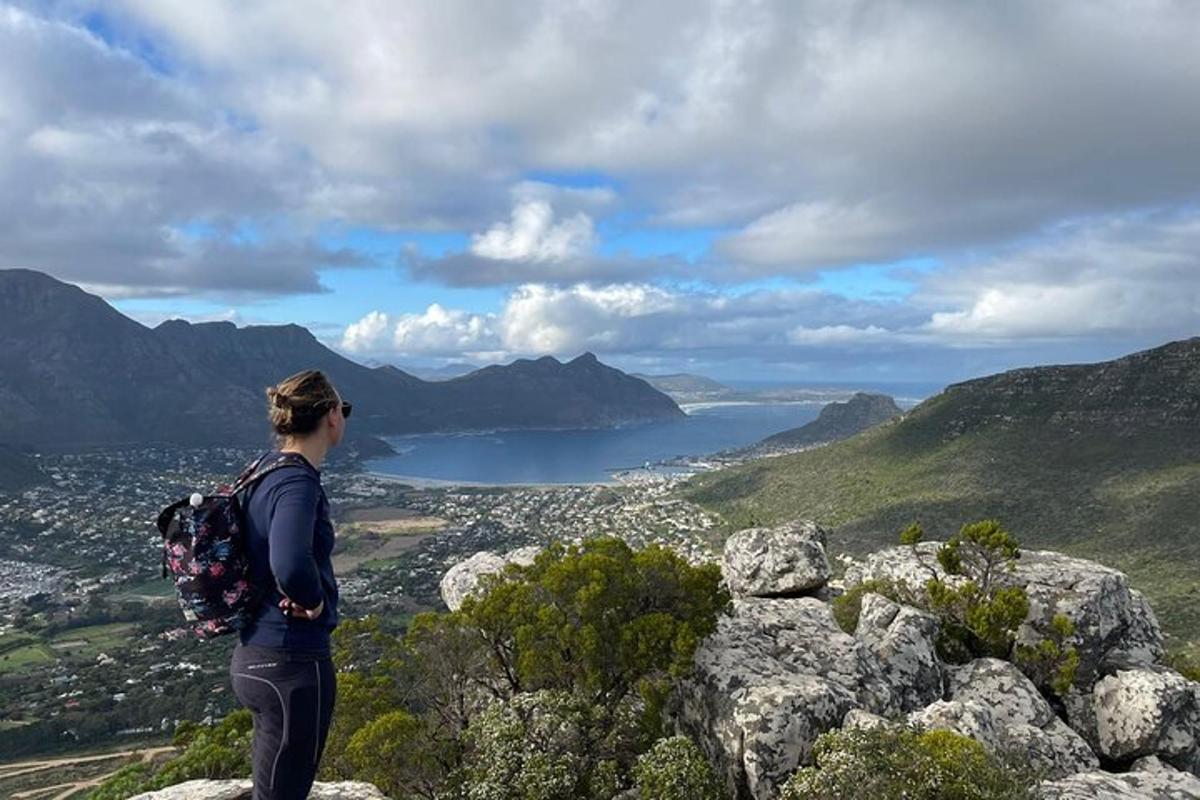 uma mulher em pé no topo de uma montanha olhando para um lago