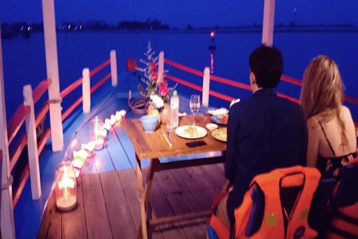 a man and woman sitting at a table on a boat