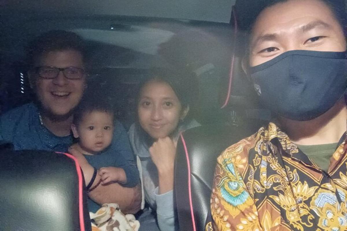 una famiglia seduta in macchina con una mascherina