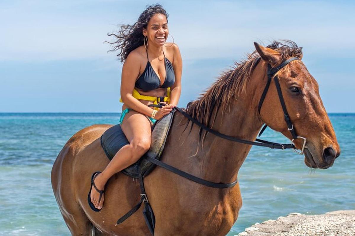 una mujer en bikini montando a caballo en la playa