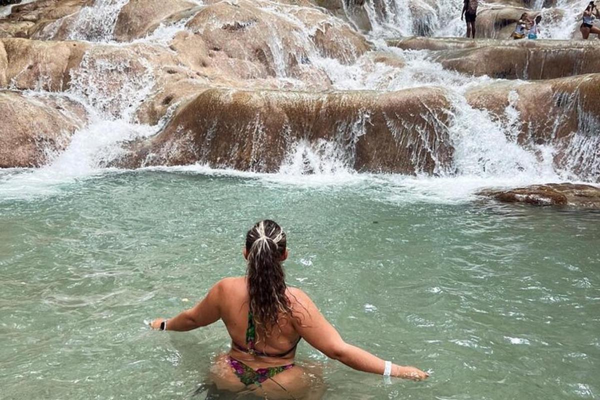 una donna in acqua davanti a una cascata