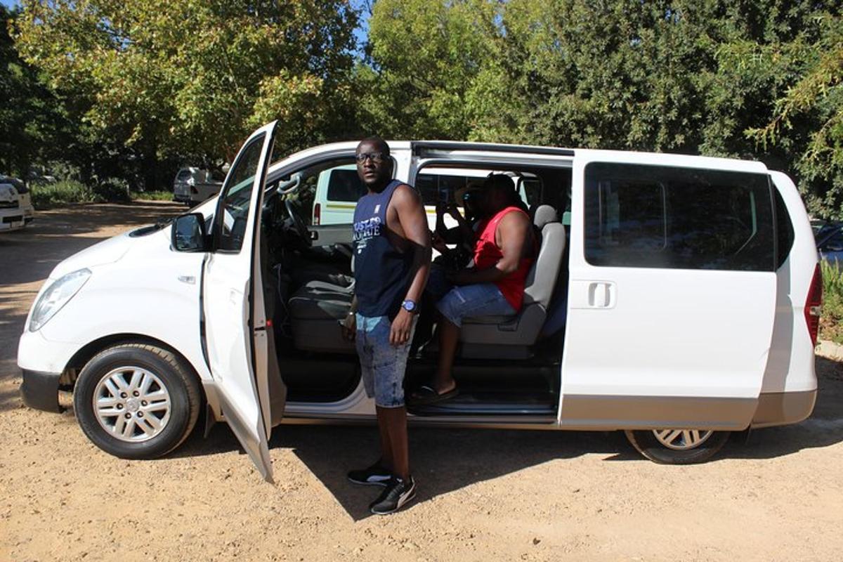 a man standing in the open door of a white van