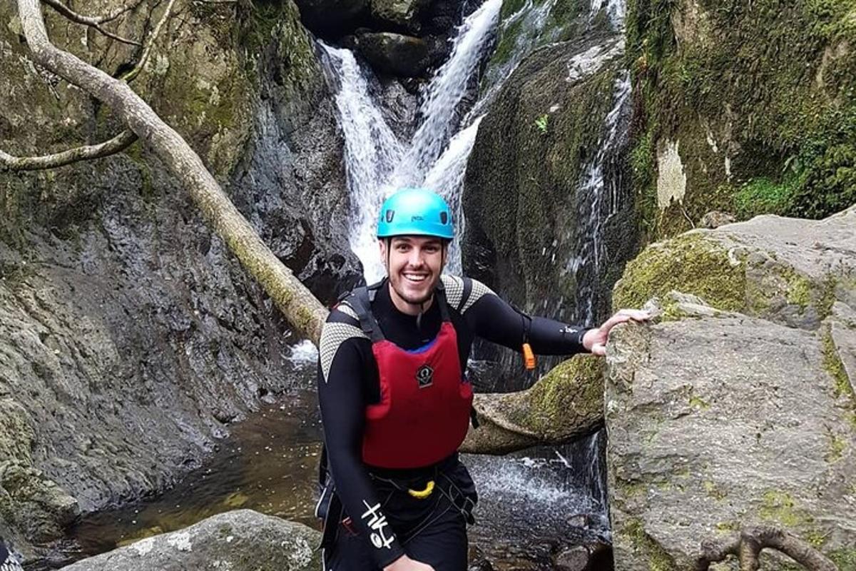 un uomo con un casco in piedi davanti a una cascata