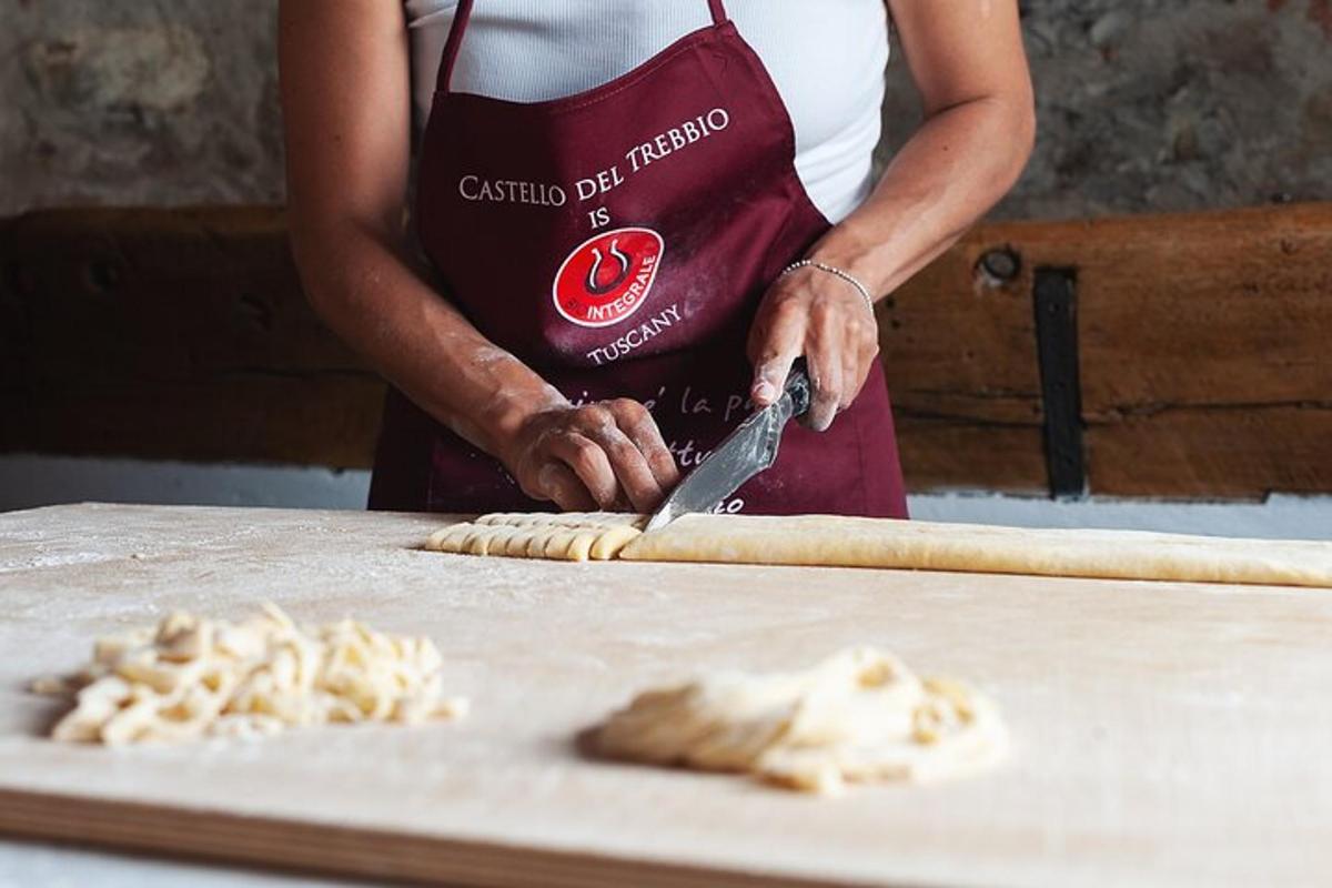 una persona con un grembiule che taglia il cibo su un tavolo