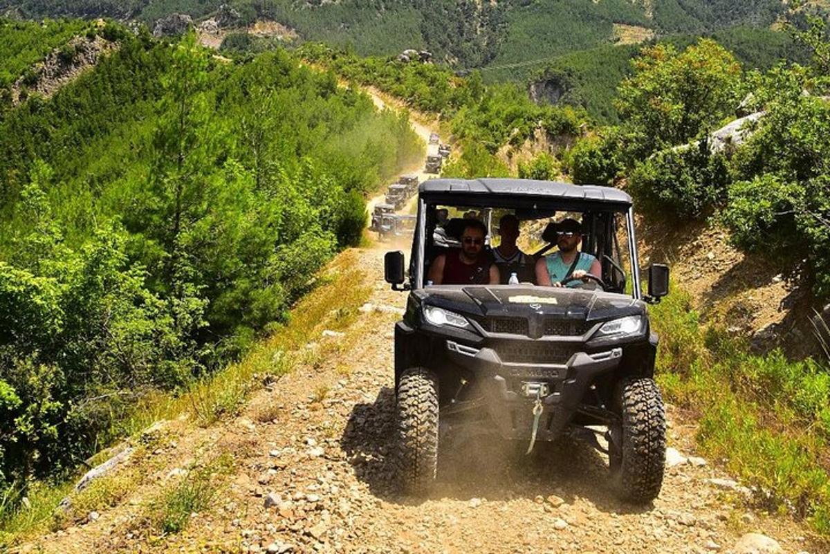 Un grupo de personas en un jeep por un camino de tierra.