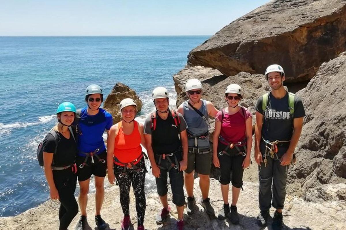 un gruppo di persone in piedi sulle rocce vicino all'oceano