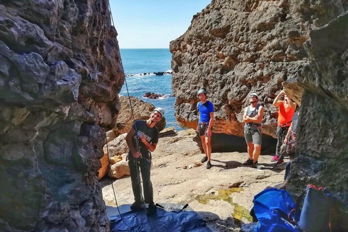 un gruppo di persone in piedi sulle rocce vicino all'oceano