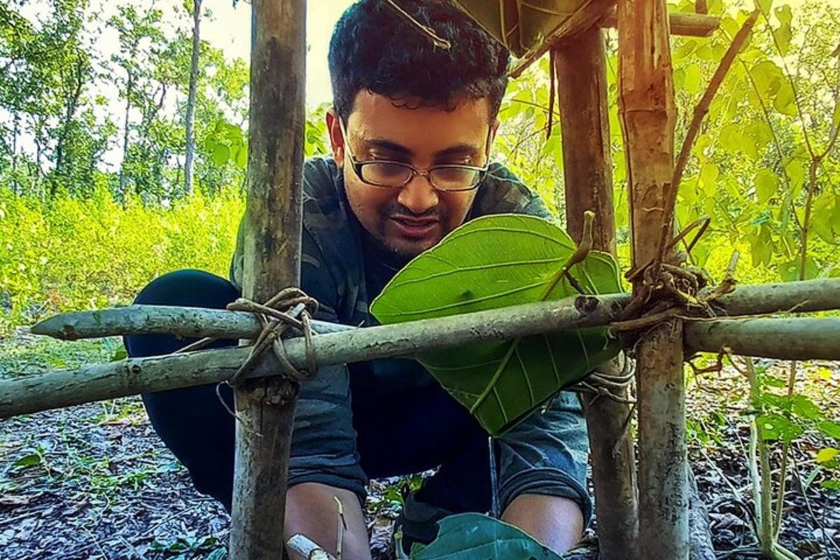 一名年轻人手里拿着一株绿色植物