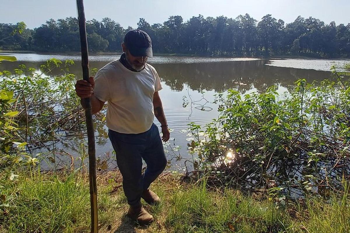 一名男子在湖前举着一根杆子
