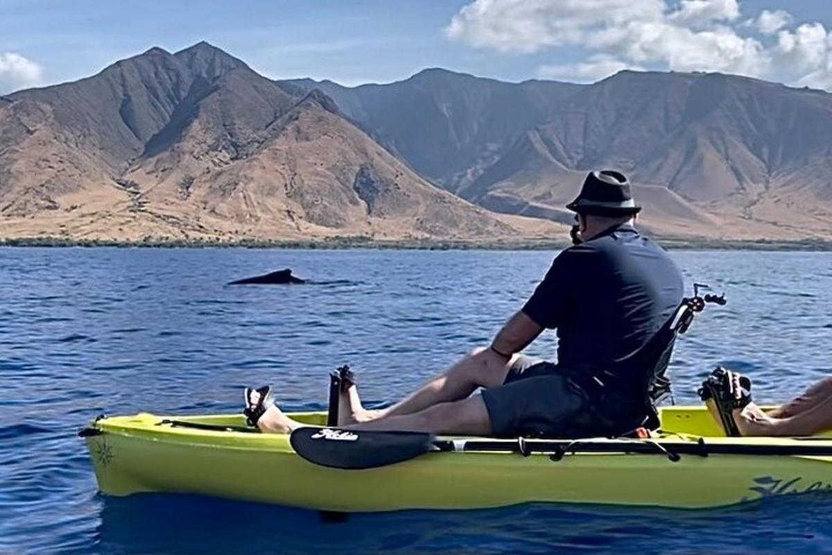 um homem sentado em um barco amarelo na água