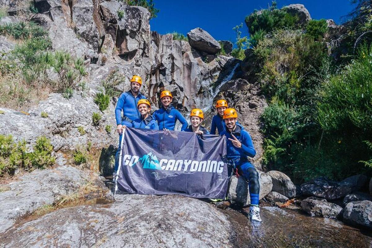 sekumpulan orang yang memegang papan tanda di atas batu