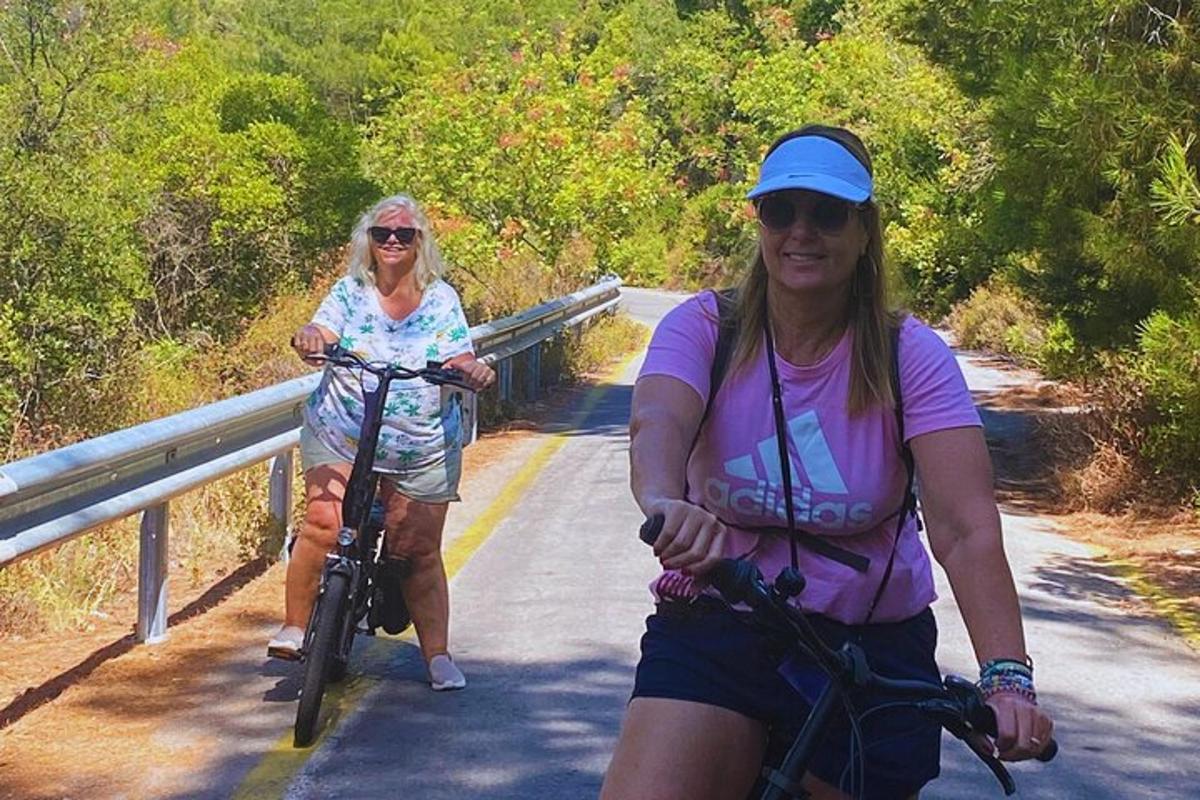 duas mulheres estão andando de bicicleta em uma estrada