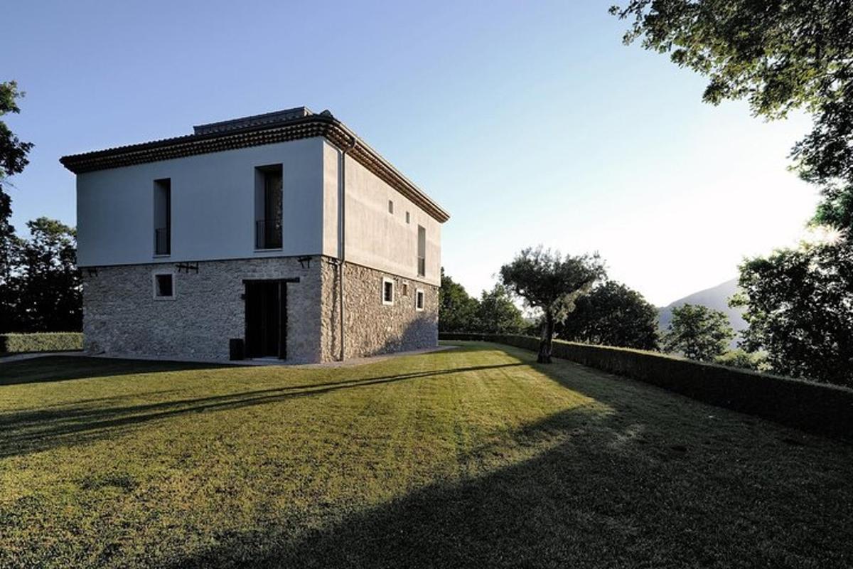uma casa em um campo gramado com um prédio