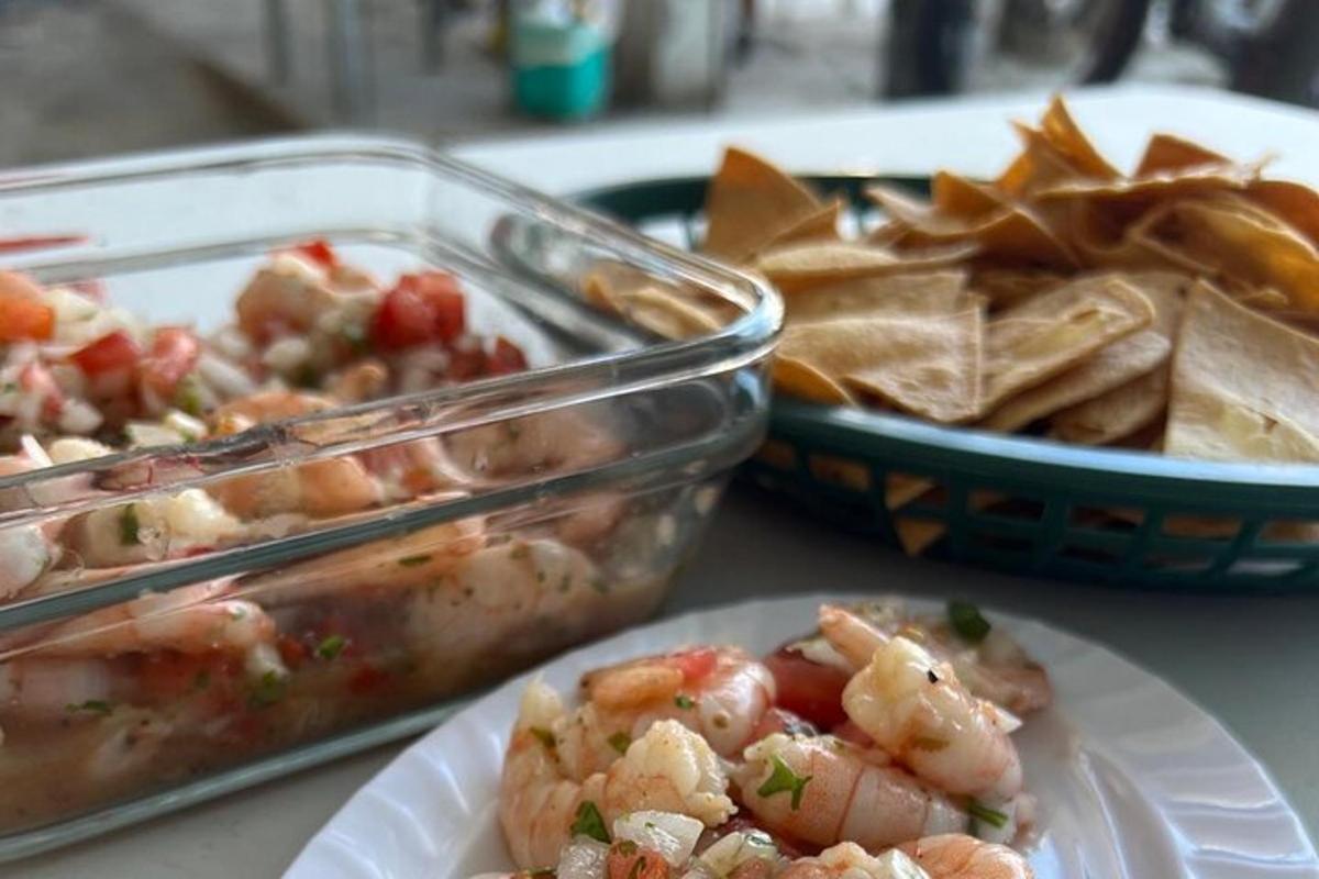 a table with a plate of food and a bowl of chips