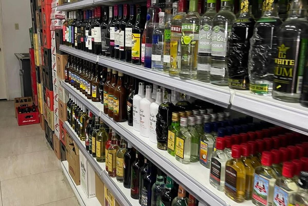 regál v obchodě plný spousty lahví alkoholu