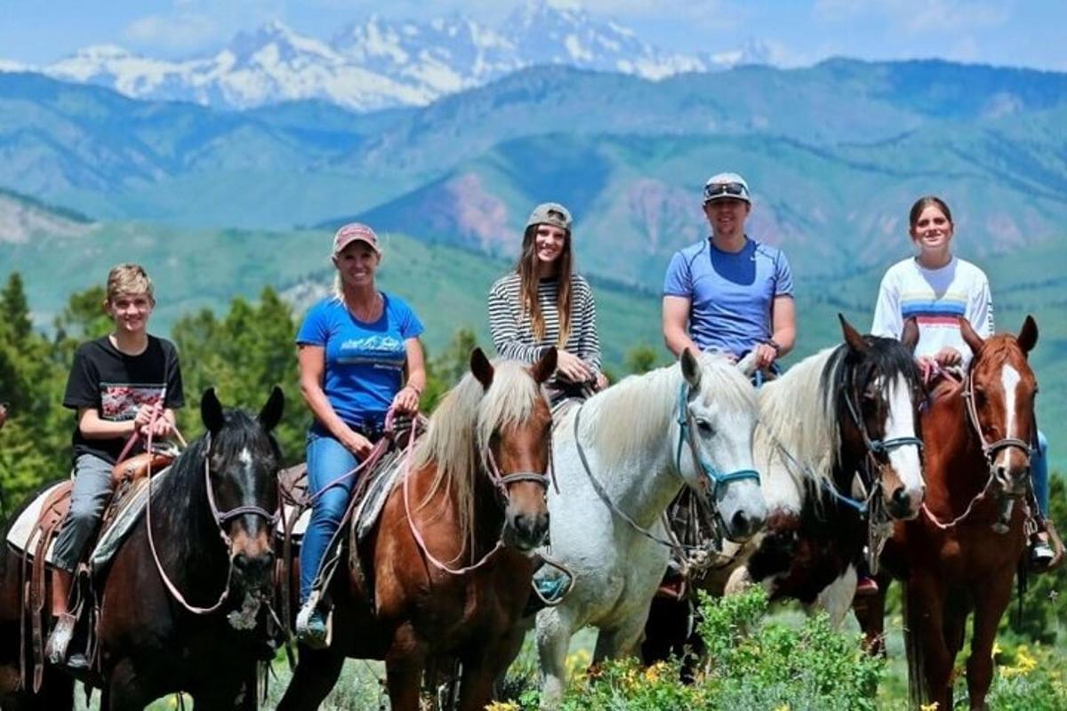 um grupo de pessoas andando a cavalo nas montanhas