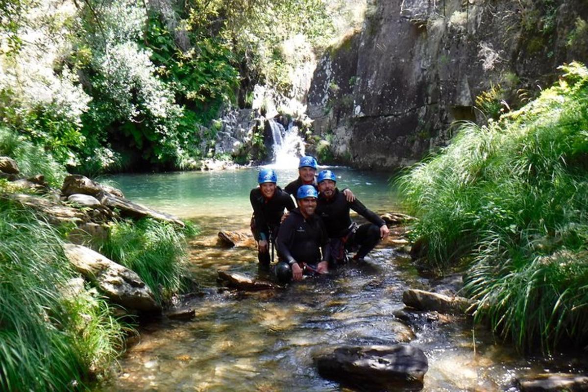 um grupo de pessoas ajoelhadas em um rio com uma cachoeira