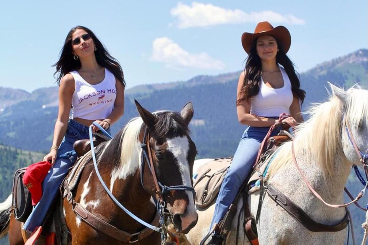 duas mulheres estão cavalgando nas montanhas
