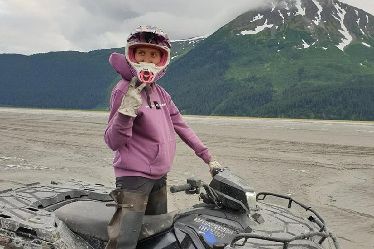 seorang gadis kecil berdiri di sebelah motosikal