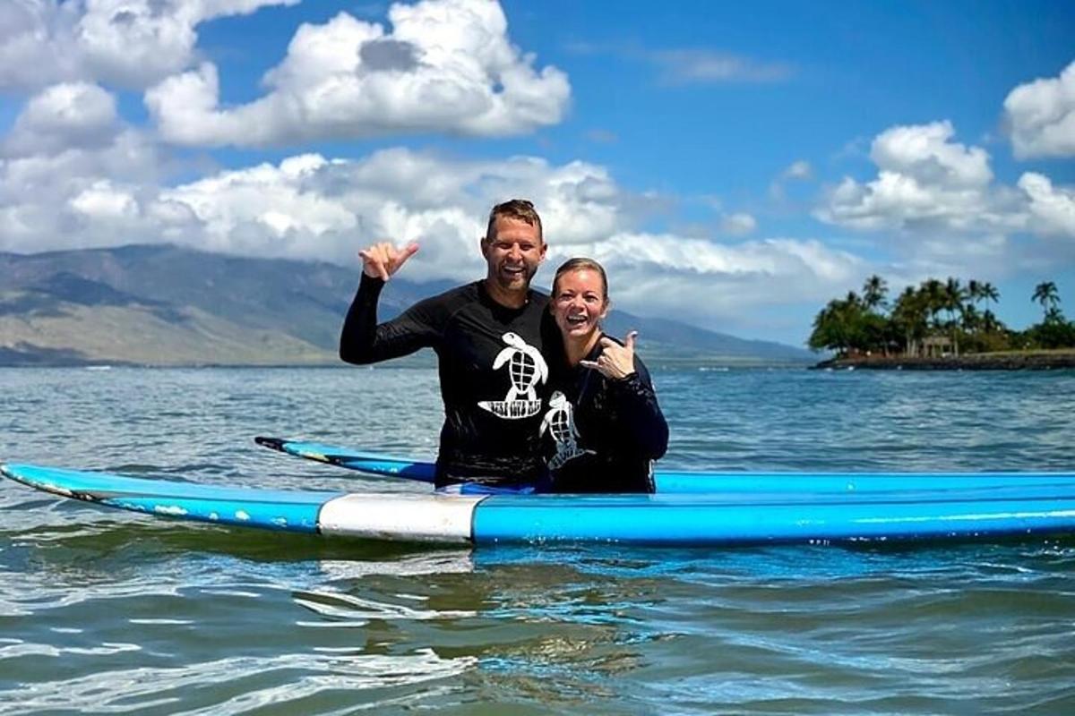 doi bărbați stând pe o placă de surf în apă