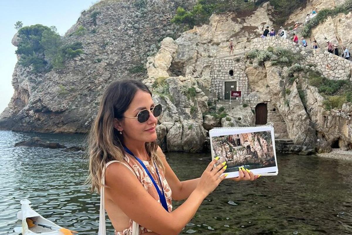 žena v slnečných okuliaroch drží obrázok útesu