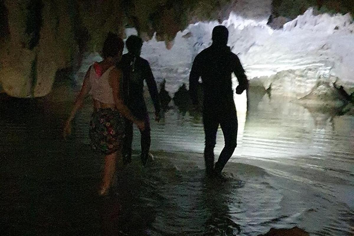 μια ομάδα ανθρώπων που περπατούν μέσα από μια σπηλιά