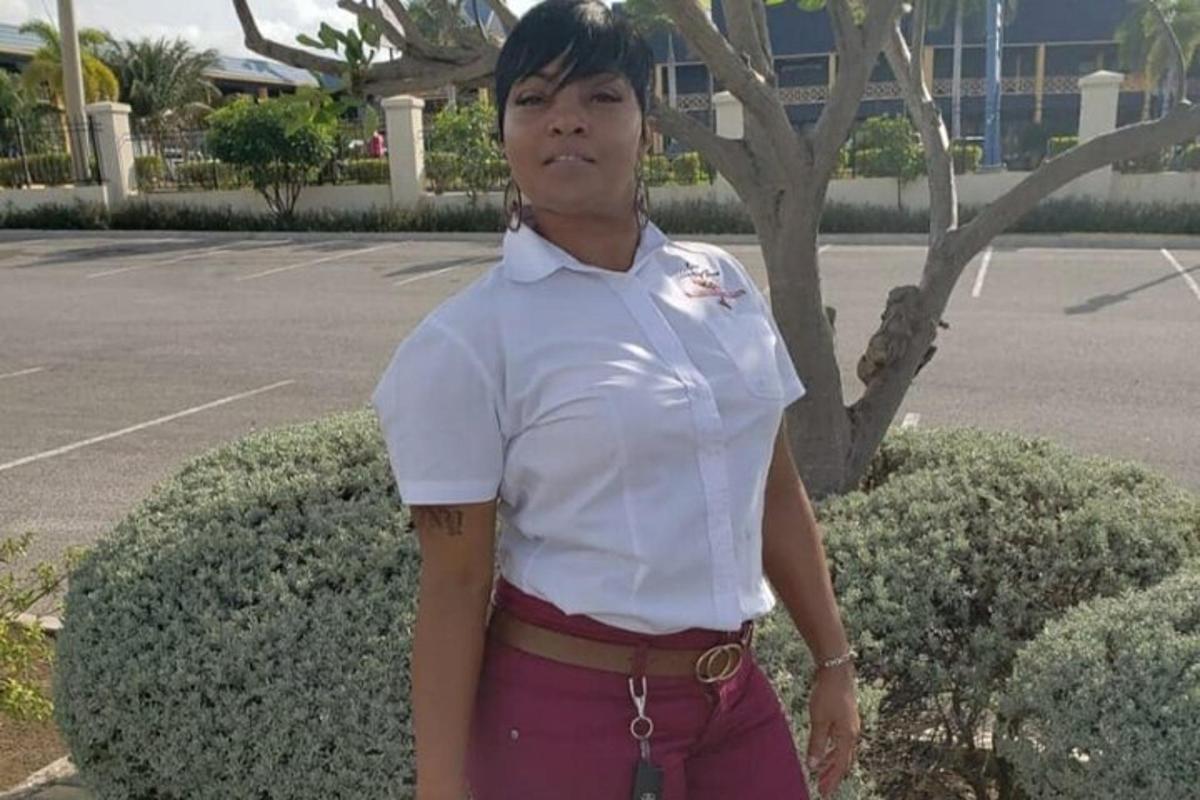 una donna con una camicia bianca in piedi accanto a un cespuglio