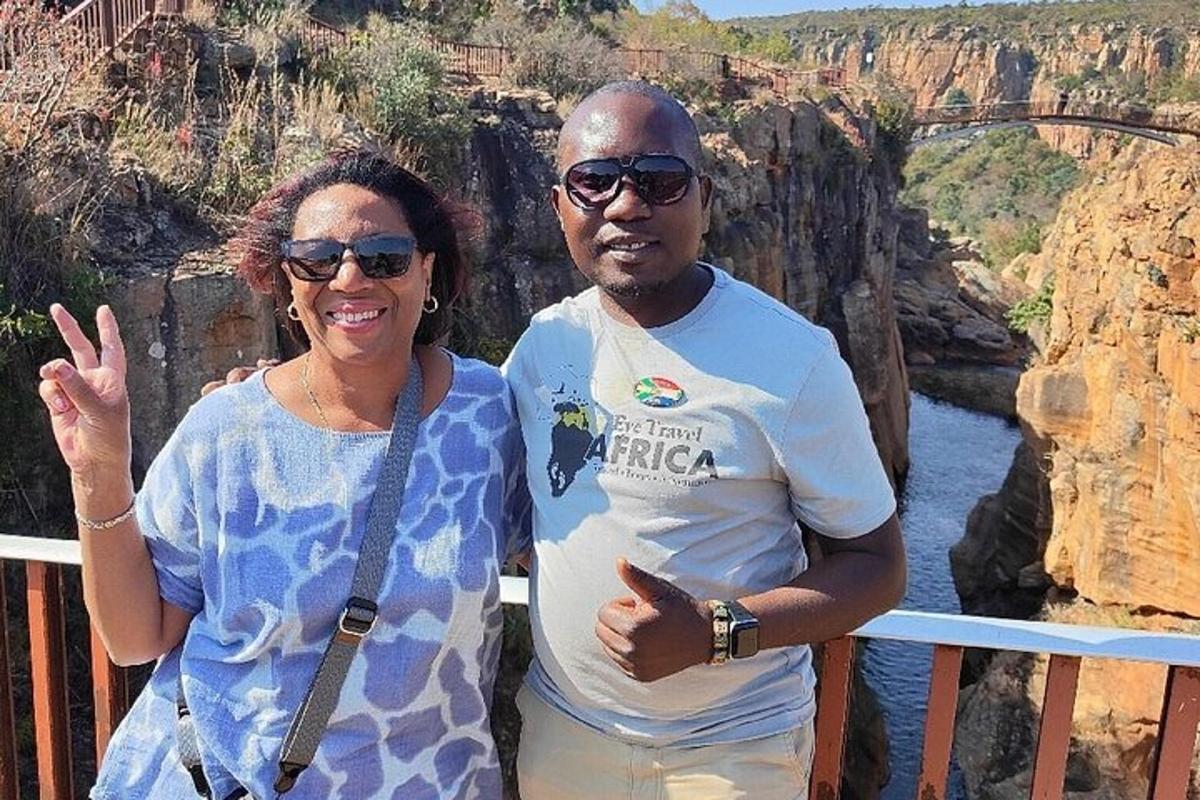 a man and a woman standing in front of a bridge