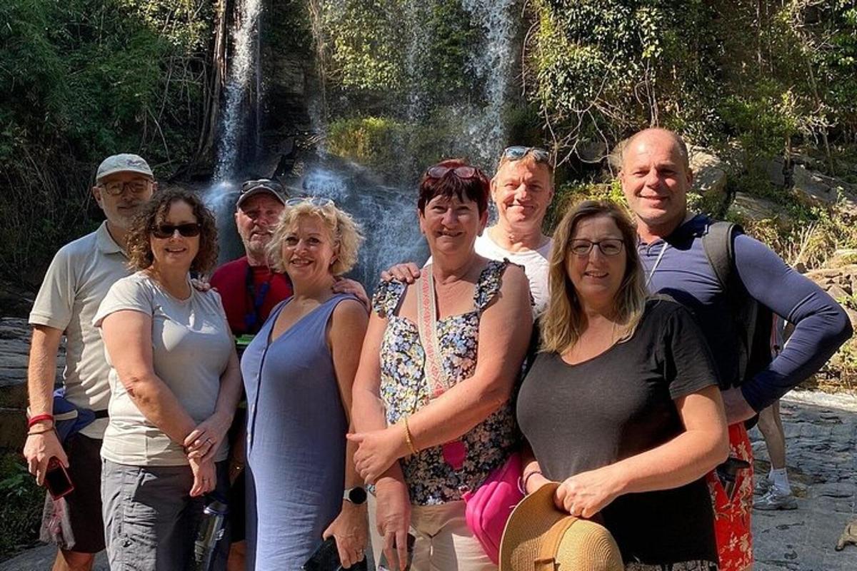 un gruppo di persone in piedi davanti a una cascata