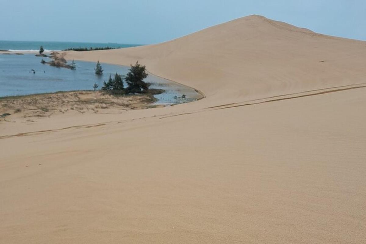 піщана дюна з водоймою вдалині