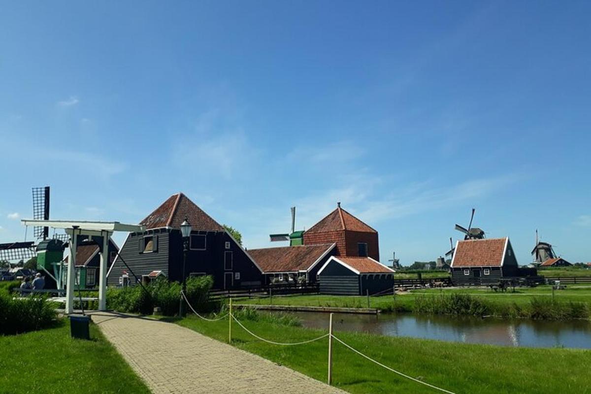 a group of houses and a river with a windmill