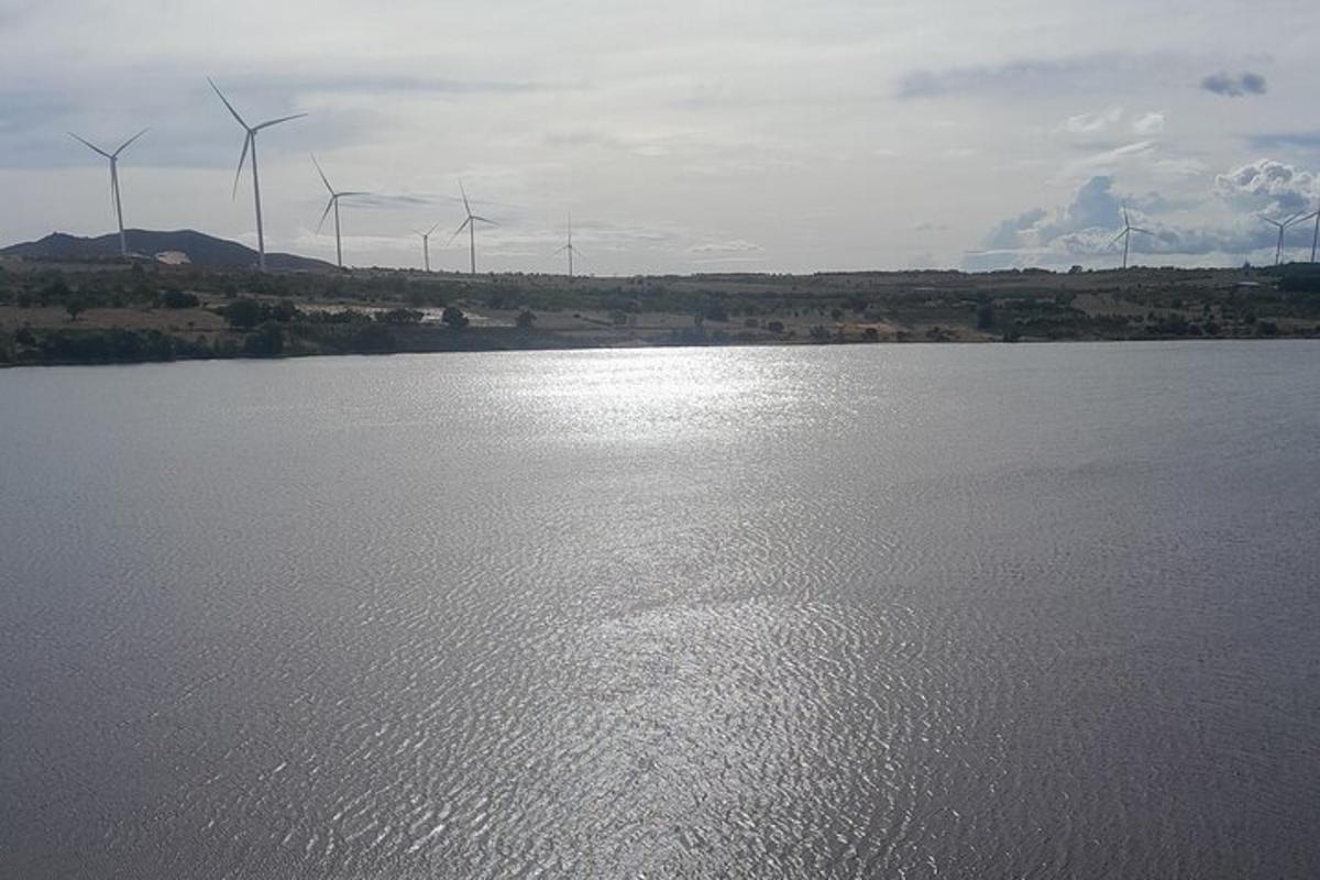 stórt vatn með vindmyllum í bakgrunni