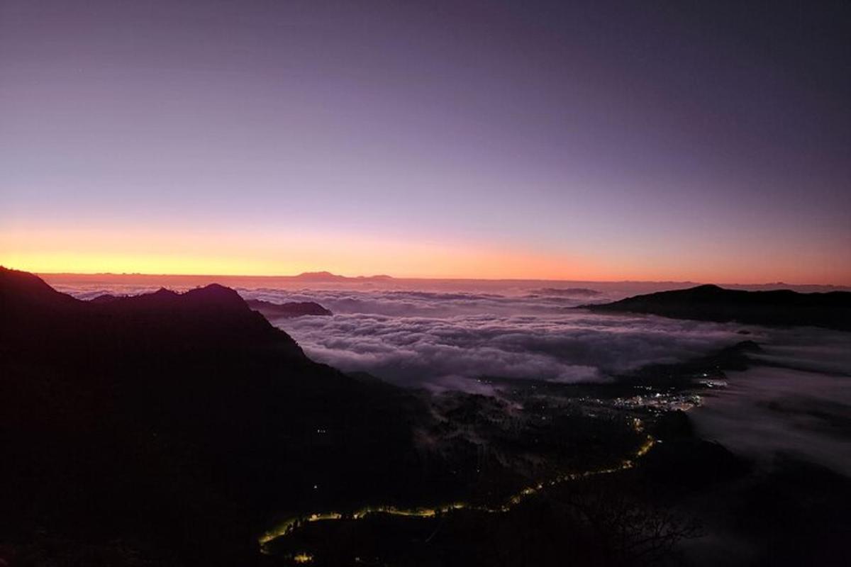 uma vista do pôr do sol do topo de uma montanha