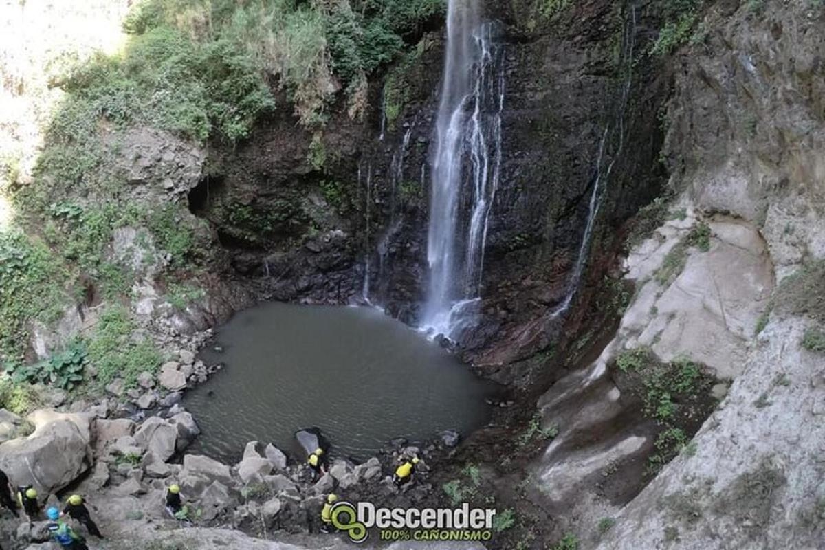 o cascadă cu oameni care stăteau în jurul unui bazin de apă