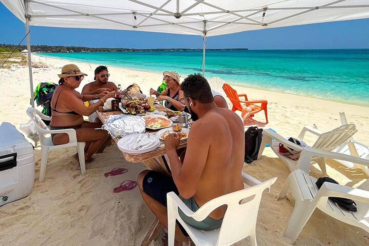 a group of people sitting at a table on the beach