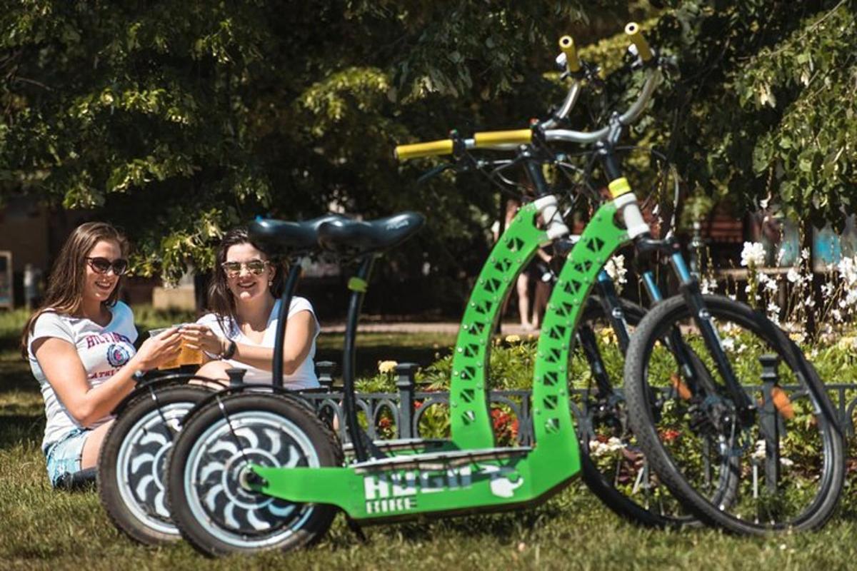 dues dones assegudes al costat d'una bicicleta a l'herba