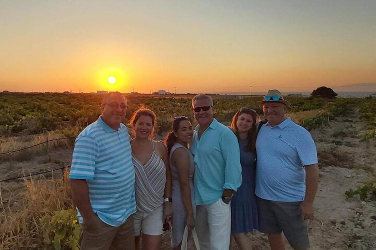 a group of people standing in front of the sunset