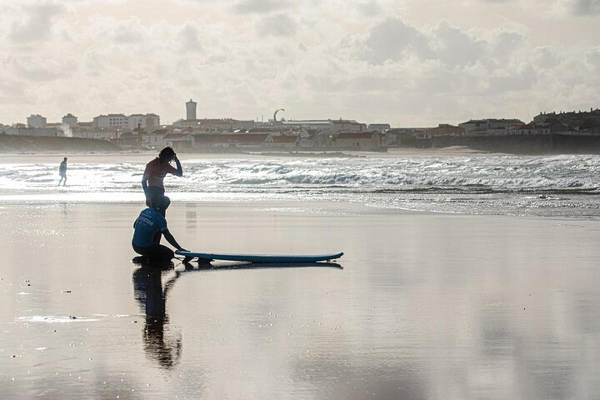 ein Mann und eine Frau sitzen auf einem Surfbrett am Strand