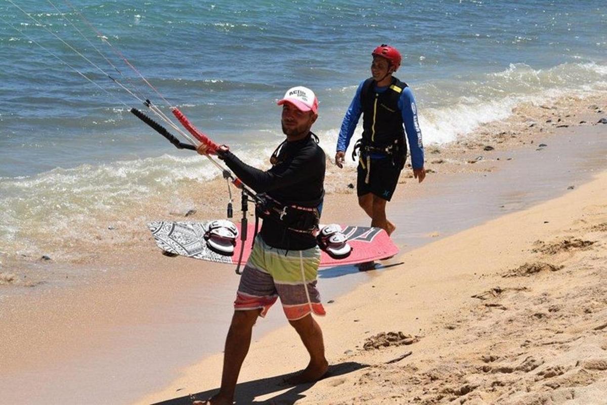 Dos hombres de pie en una playa sosteniendo una cometa