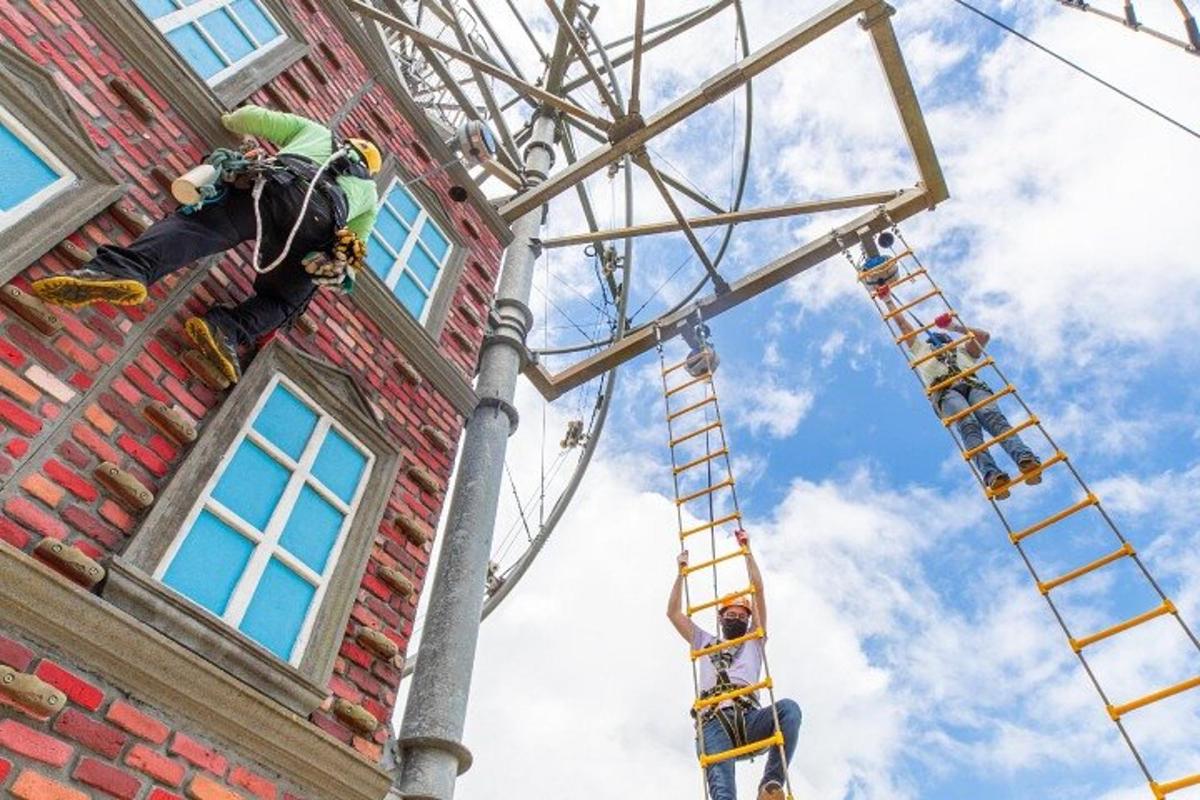 a man is painting the side of a building with a ladder