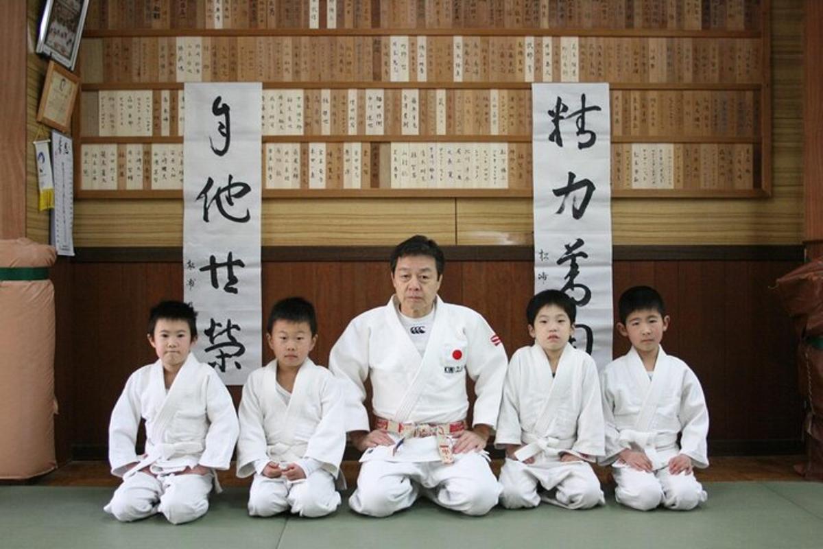 ryhmä lapsia ja mies valkoisessa judossa