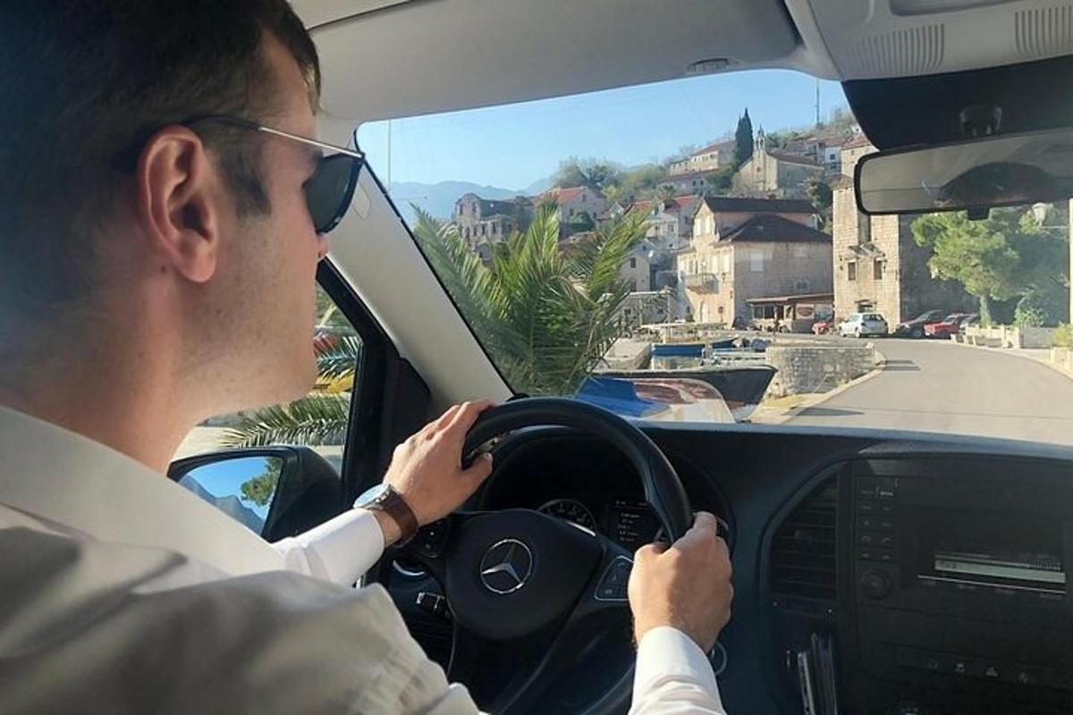 a man driving a car on a city street