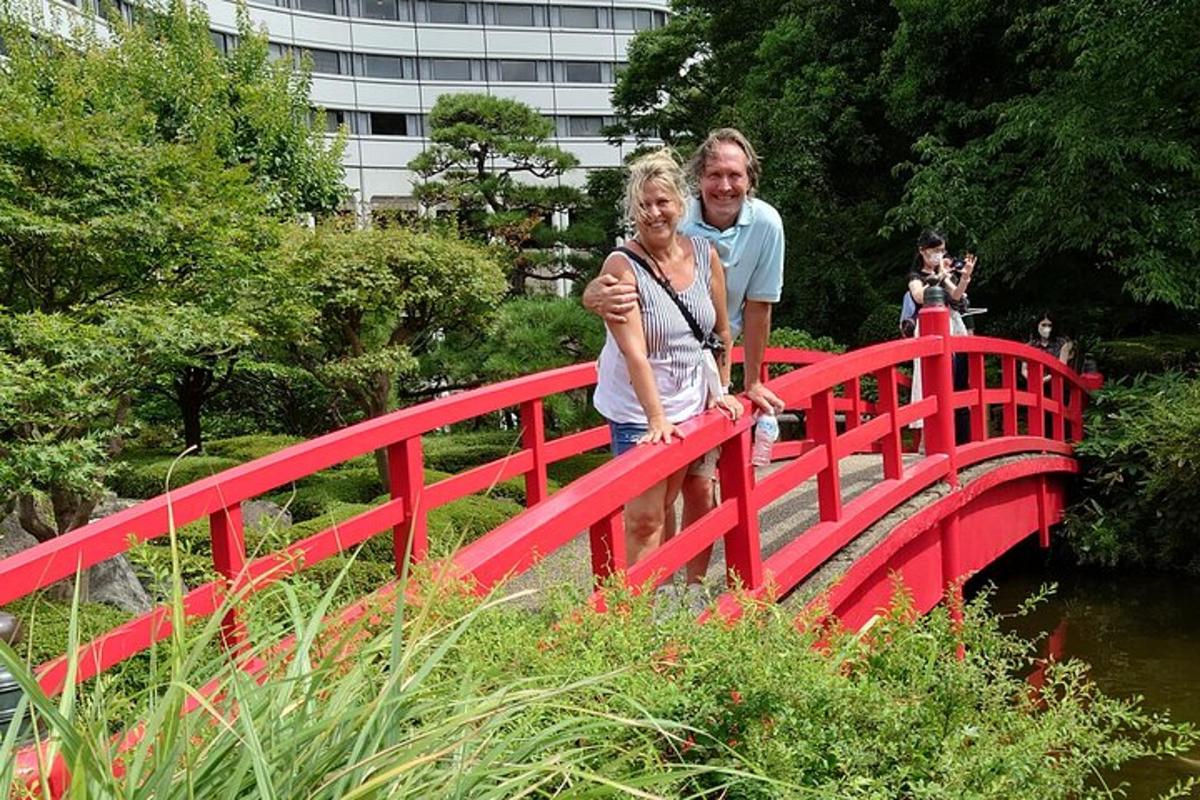 un uomo e una donna in piedi su un ponte rosso